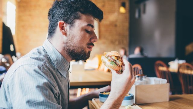 millennial eating burger ways we're unhealthy