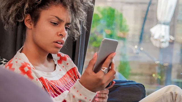 woman looks at phone shock disbelief