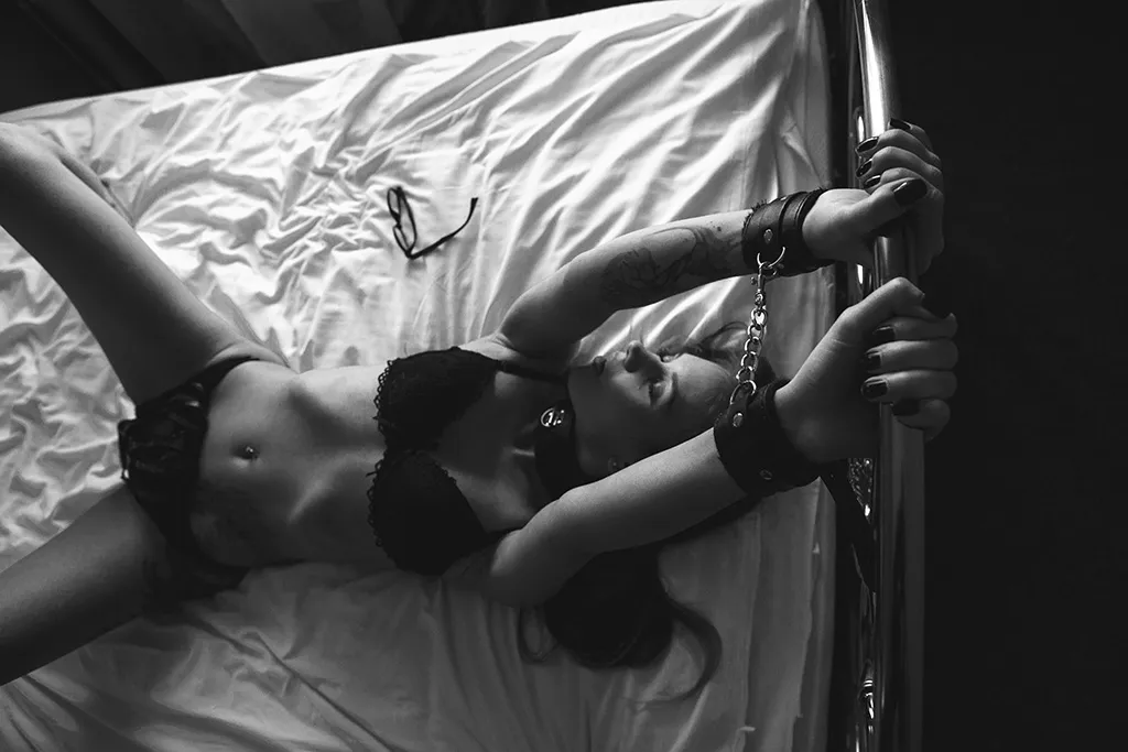 woman chained to bed in bdsm kinkly