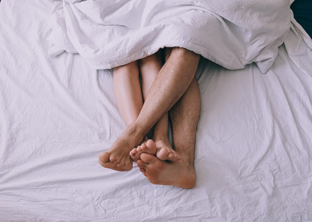 couple's feet in bed 40 things you shouldn't believe after 40