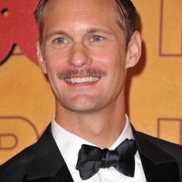 alexander skarsgard and his completely misguided facial hair smile stupidly on the emmy's red carpet
