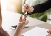 woman handing keys to another woman, downsizing your home