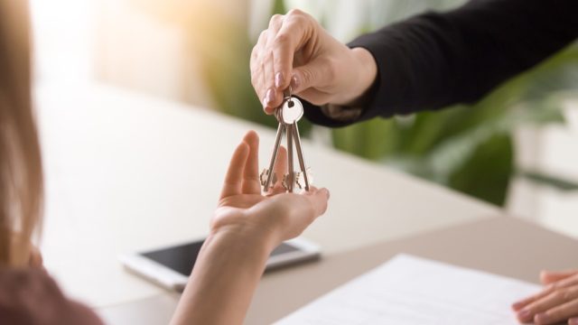 woman handing keys to another woman, downsizing your home