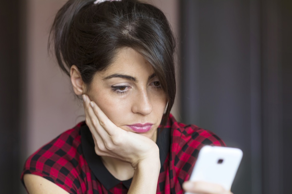 disappointed woman reading phone commit