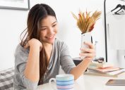 young asian woman looking at her phone and smiling