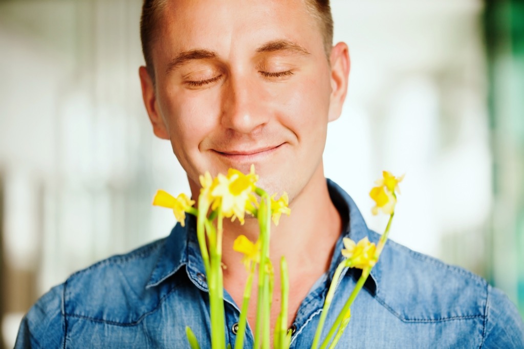 man smelling flowers advice you should ignore over 40