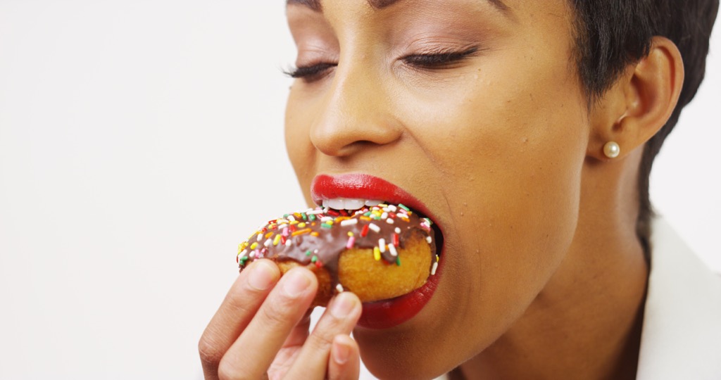 woman eating donut ways we're unhealthy