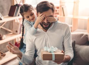 girl giving unusual gifts to dad man