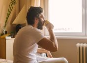 man drinking coffee in bed, things you should clean every day