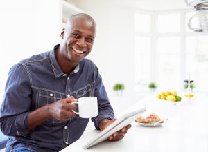 man holding coffee smiling with breakfast