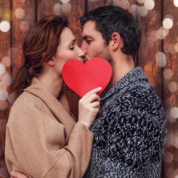 couple kissing behind a heart - signs you're in love