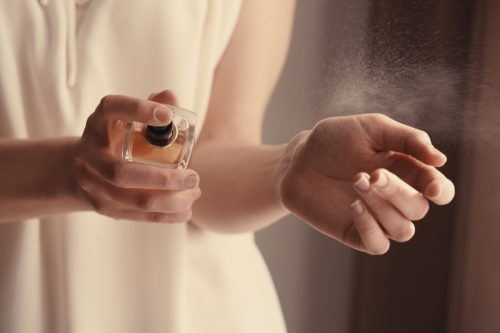 woman spraying perfume, things you should never store in basement
