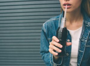 woman drinking soda, a bad habit after 40