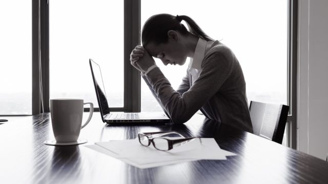 stressed out woman at a desk feeling guilty