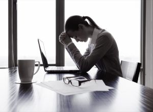 stressed out woman at a desk feeling guilty
