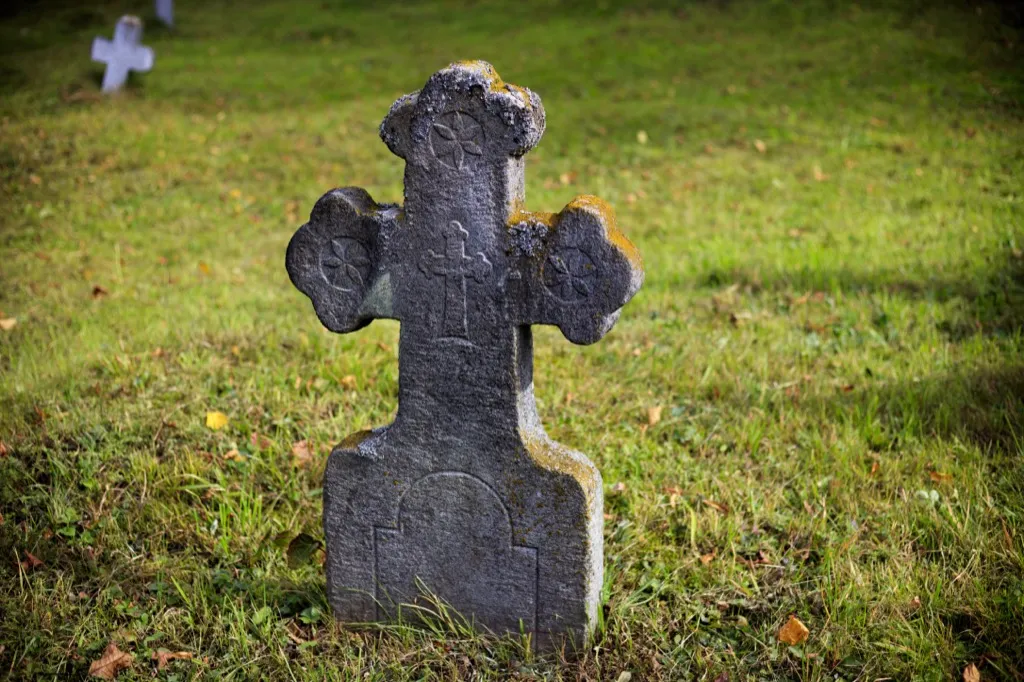 Cross-shaped grave stone in cemetery