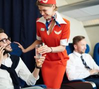 flight attendant helping a first class flyer