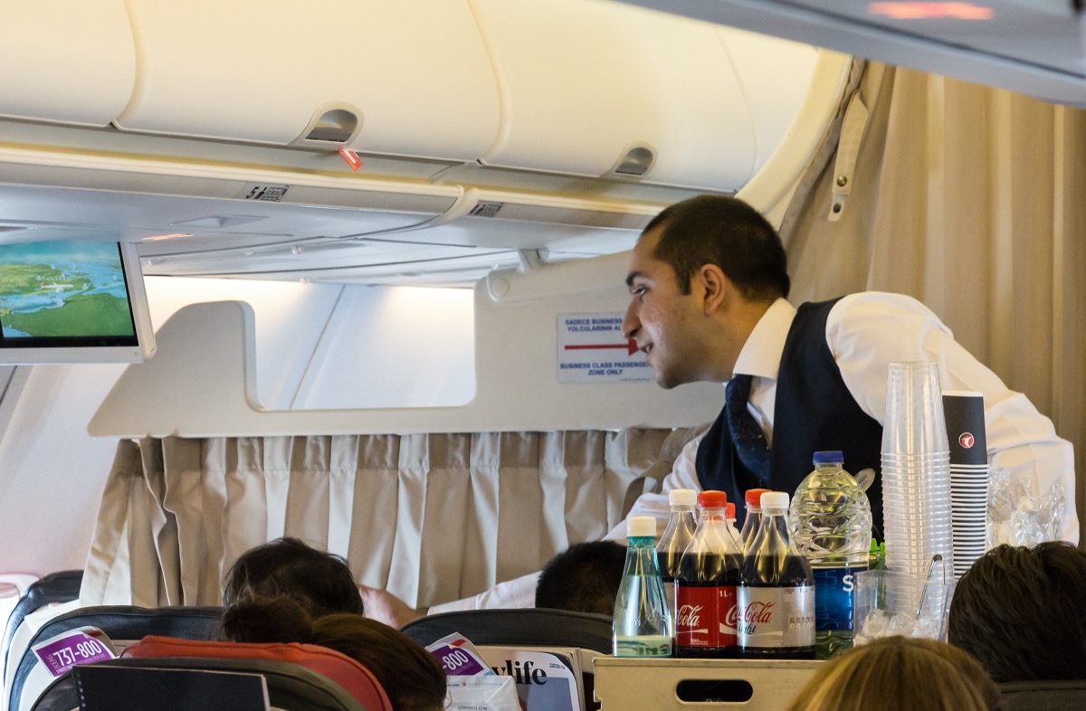 flight attendant feeding a passenger