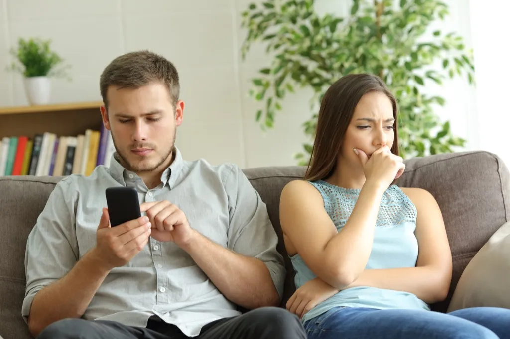 Man Looking Through Partner's Social Media Signs Your Partner Misses Her Ex