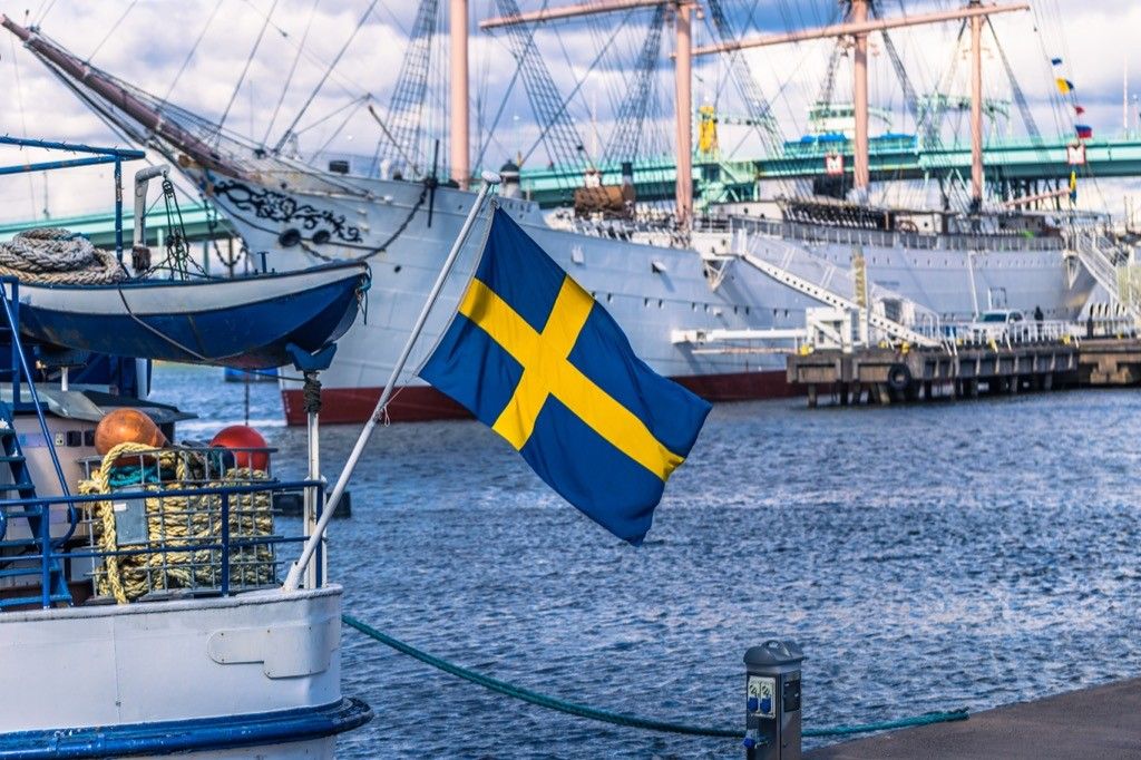 Boat in harbor flying Swedish flag