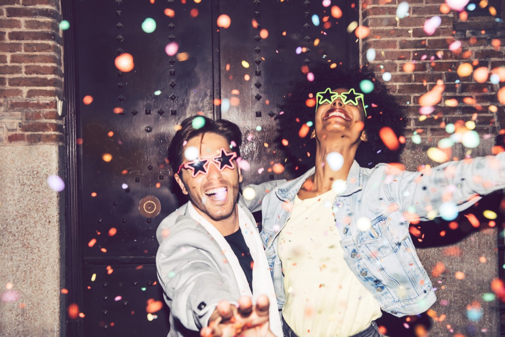 man and woman wearing fun glasses with confetti