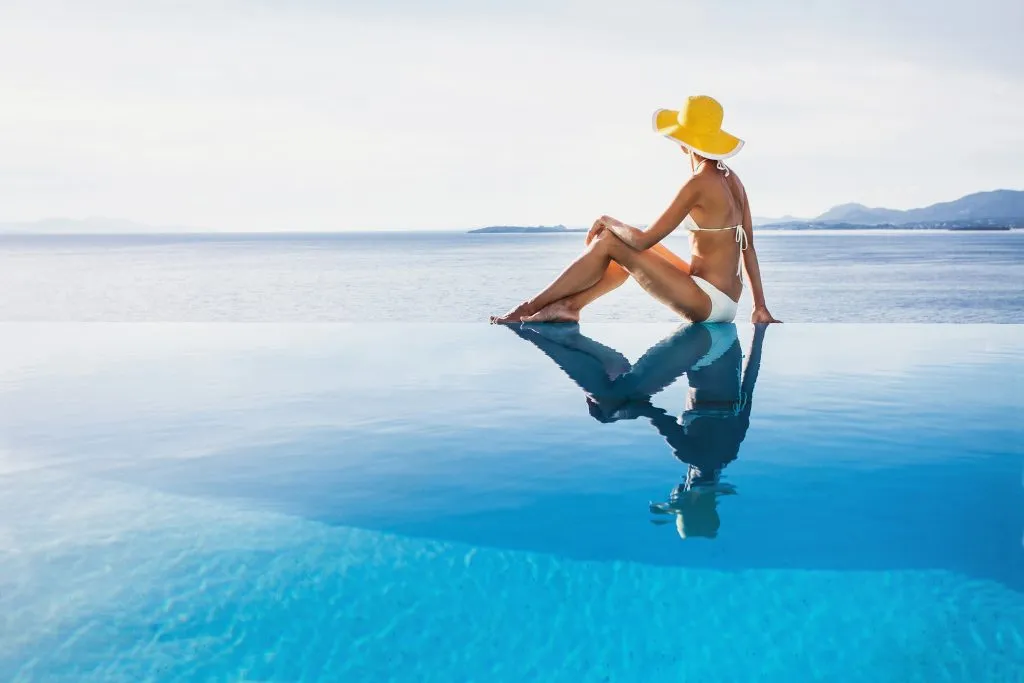 woman infinity pool vacation Science-Based Happiness Hacks 