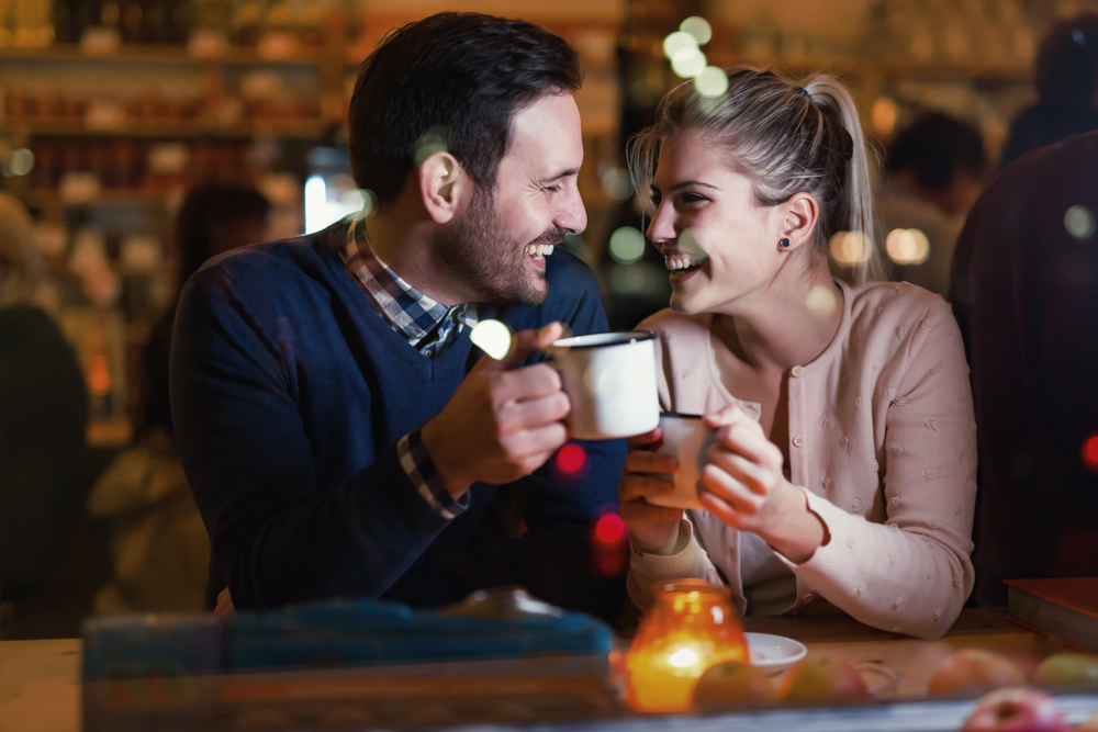 man and women on date with drinks and candle - what to say on a first date