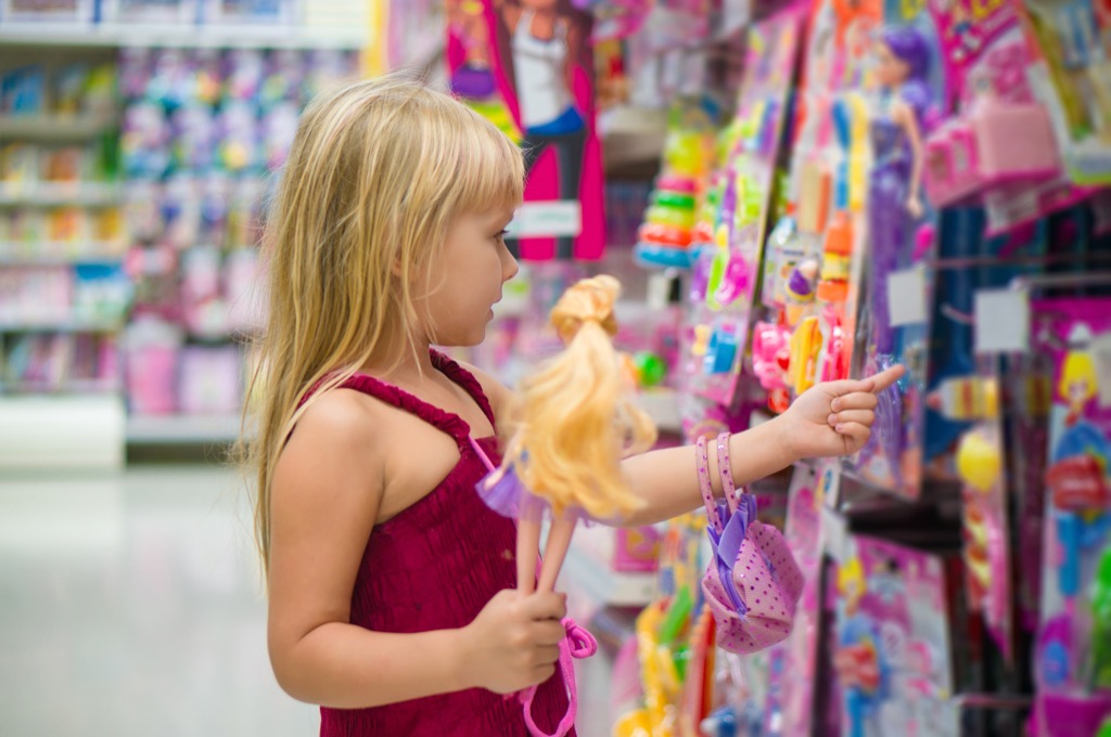Girl in toy section holding a barbie