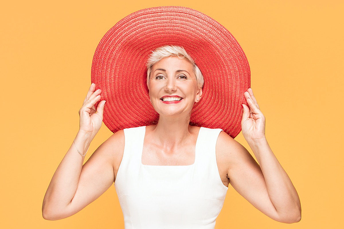Femeie de vârstă mijlocie într-o pălărie mare de soare colorată