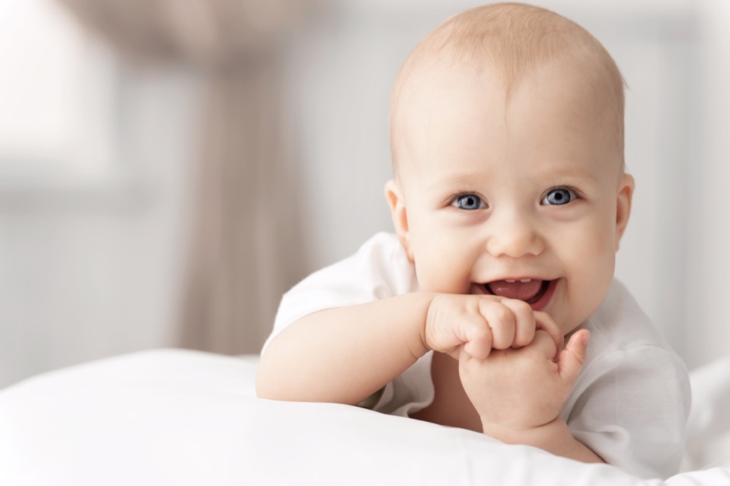 smiling baby in bed - literary baby names 