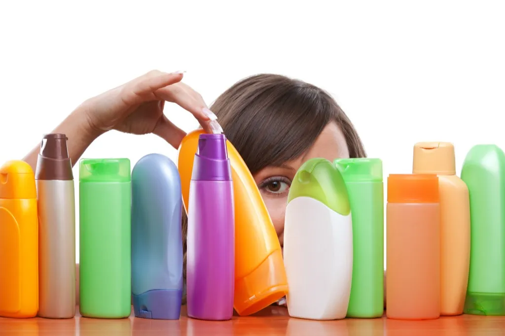 woman with shampoo bottles products you should always buy generic