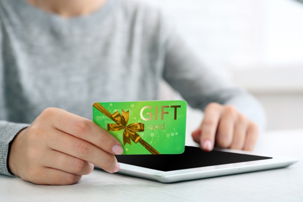 white woman holding gift card