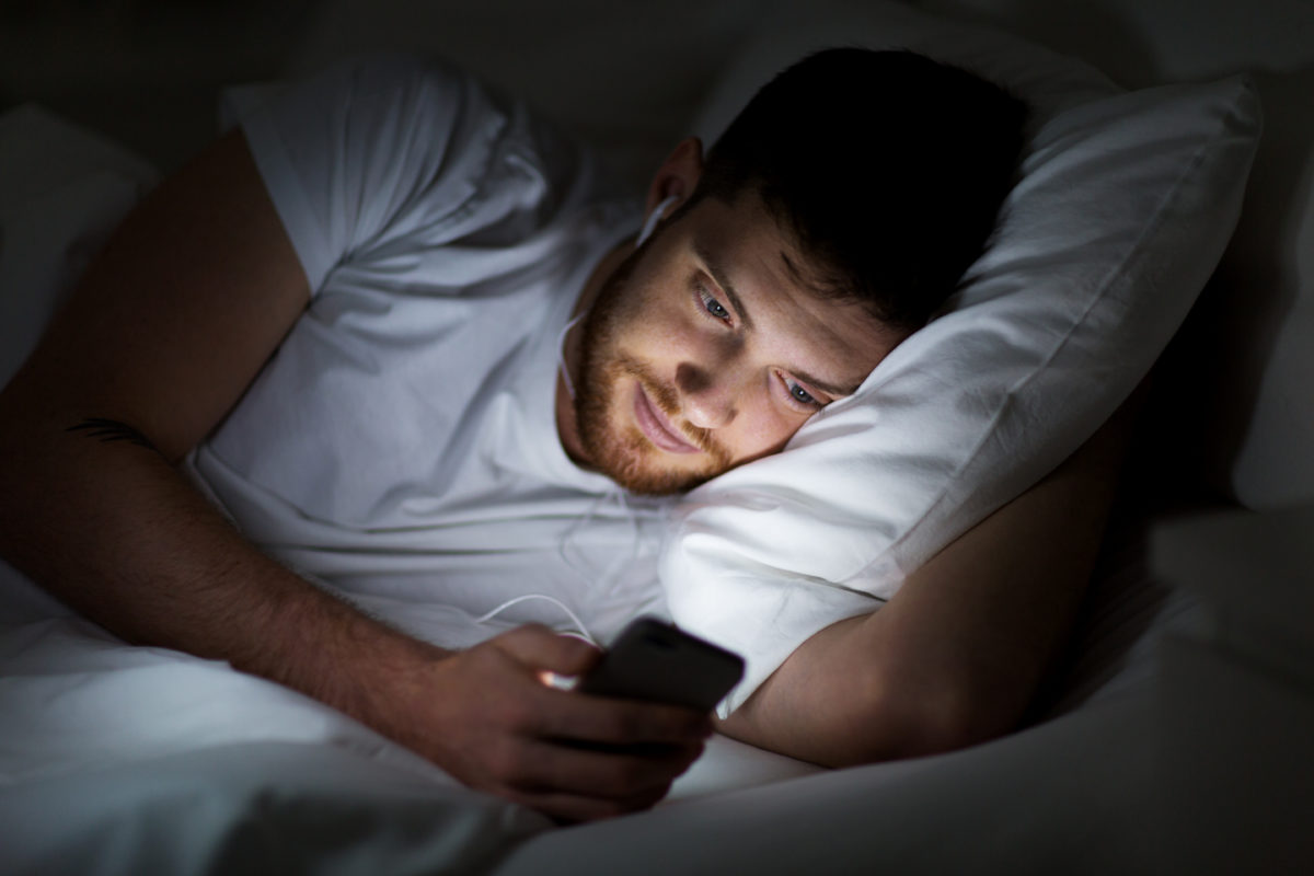 Man on Phone in Bed