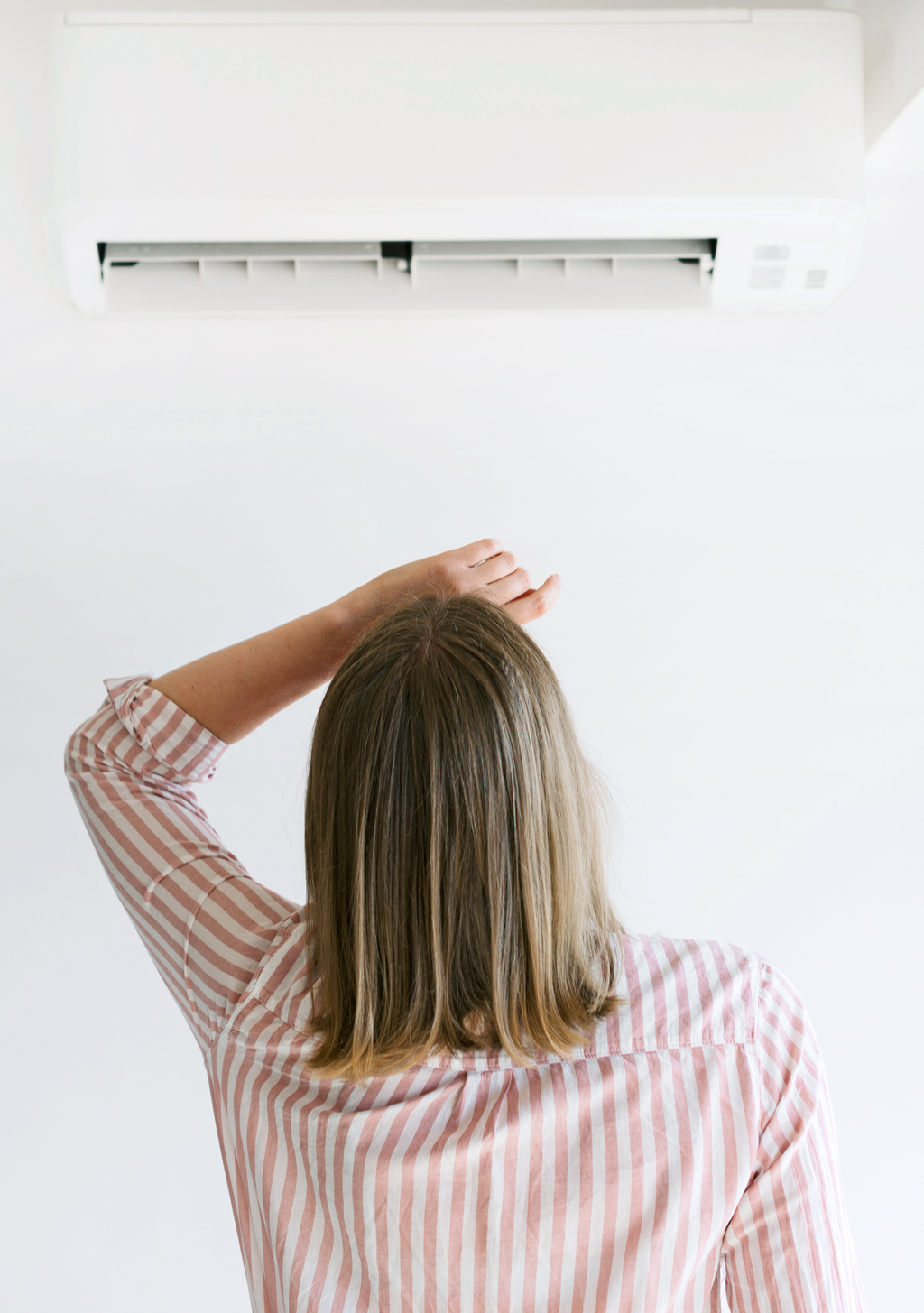 Woman with Air Conditioner ways to bring down a/c bill