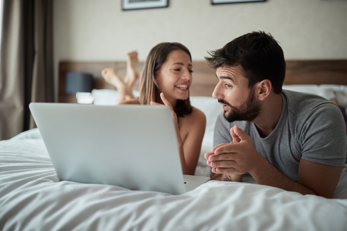 couple using a laptop computer on a bed