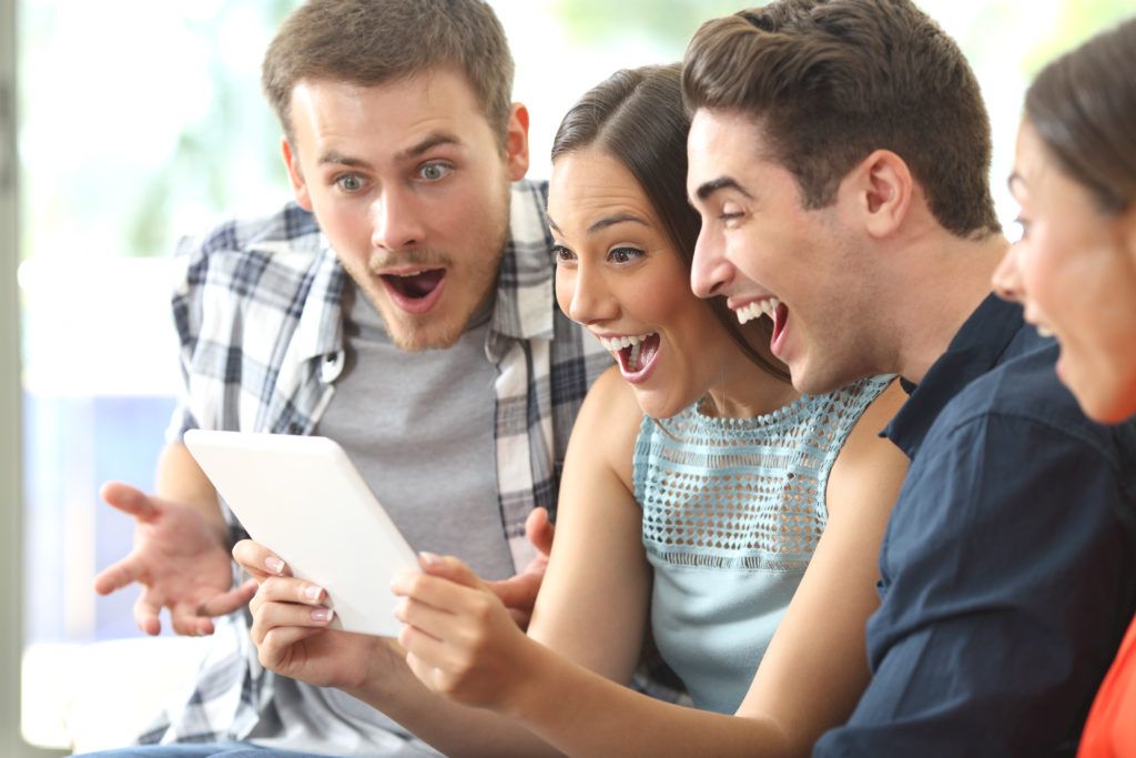 group looking at tablet in excitement, facts about the lottery