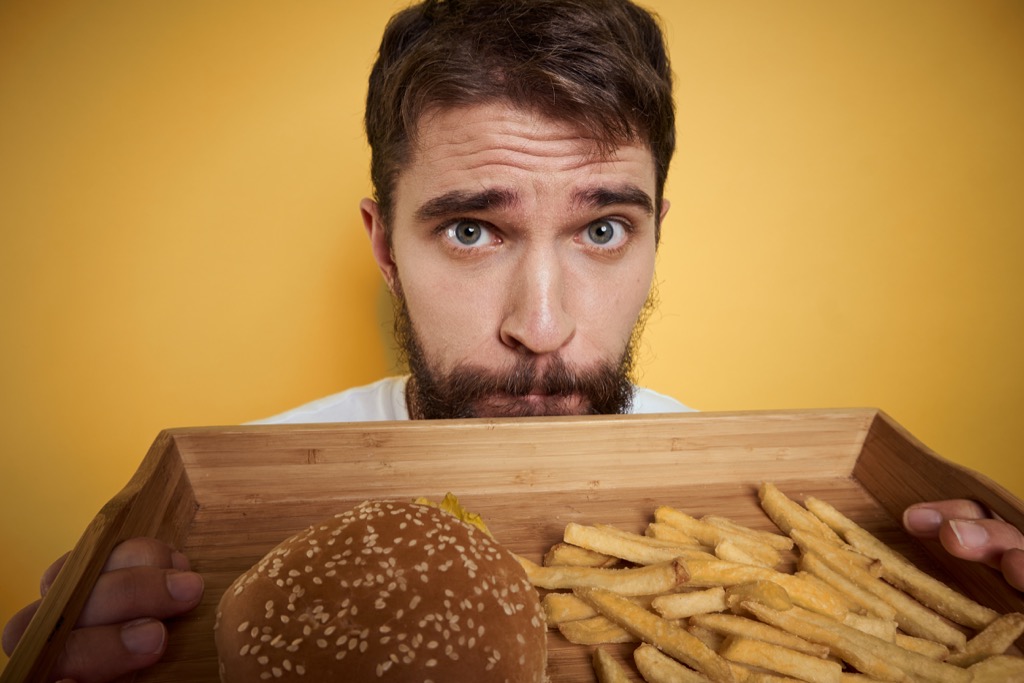 man eating burger and fries