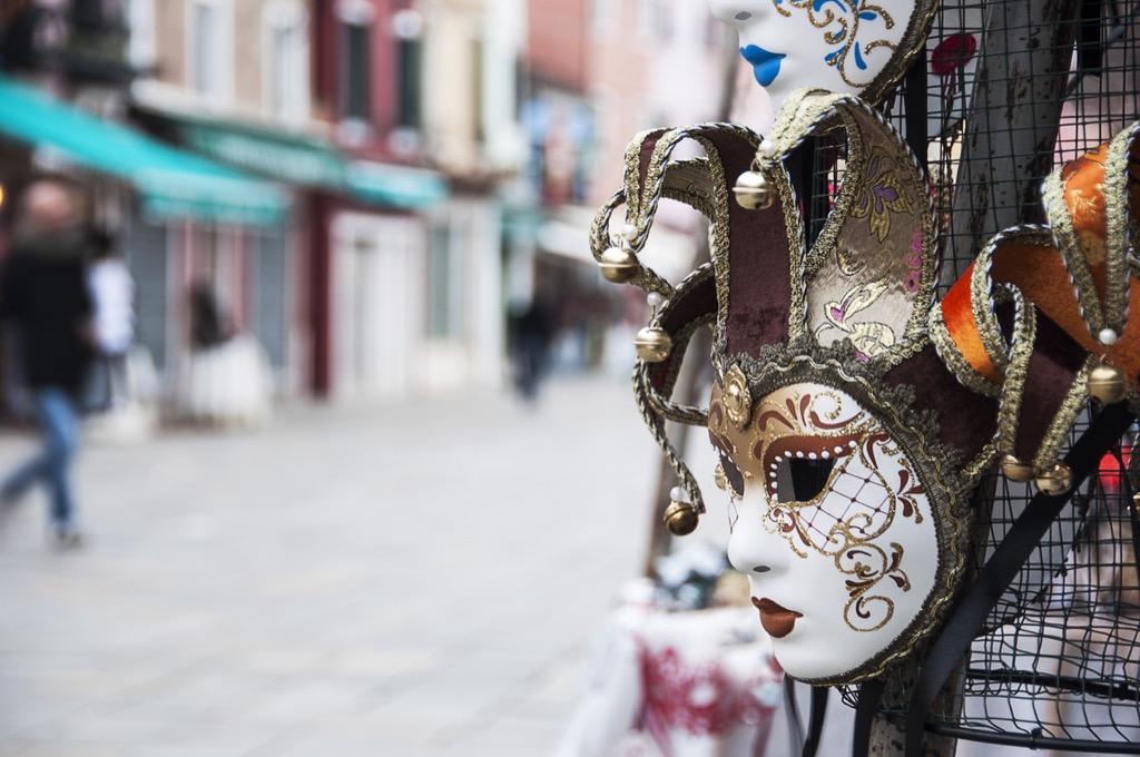 Venetian mask hanging outside a shop on an Italian street