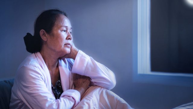 middle aged woman awake in bed at night