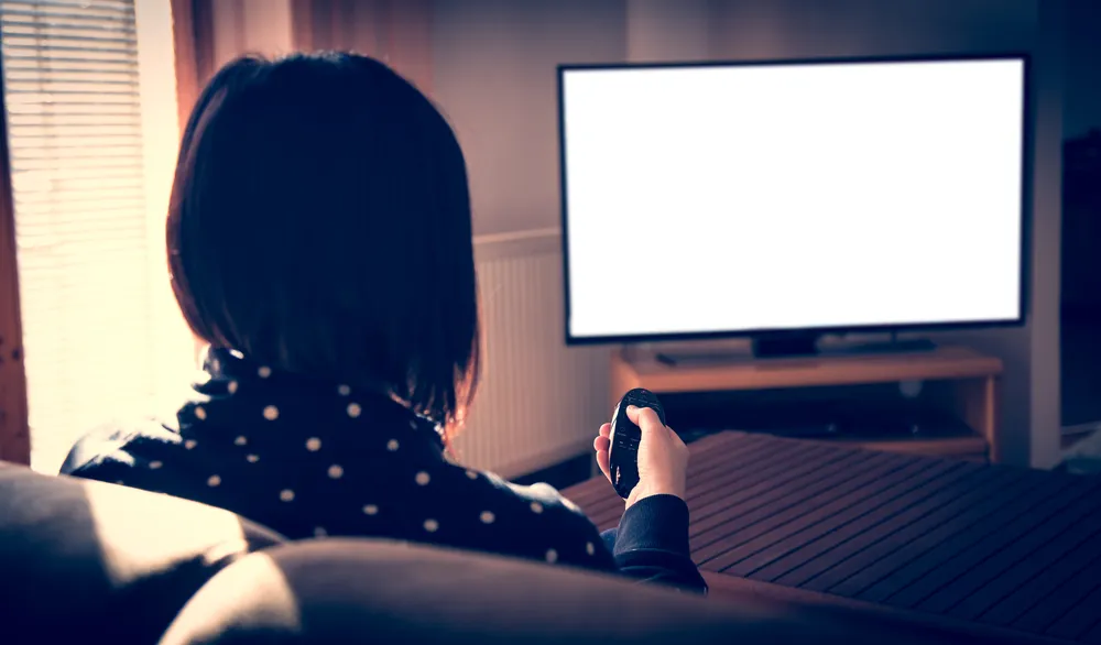 woman watching tv regrets
