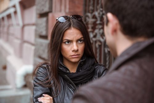 Femeie enervată care vorbește cu un bărbat în aer liber, comportament nepoliticos