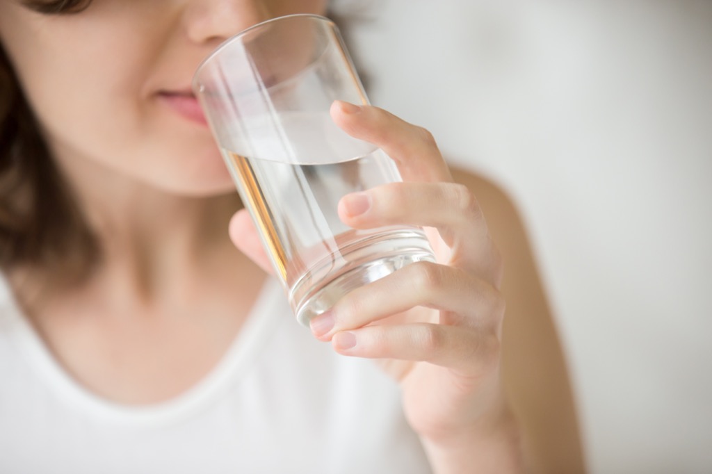 woman drinking a glass of water Anti-Aging Tips You Should Forget