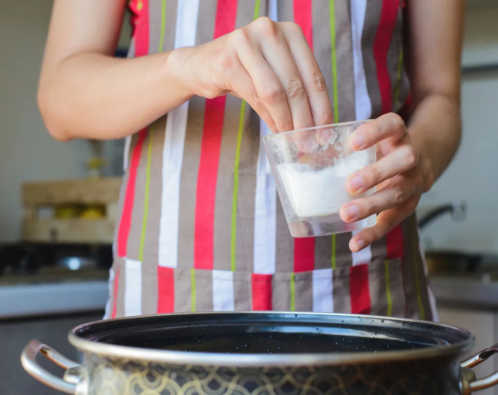 Woman Adding Salt to a Pot of Water Bad Habits For Your Heart