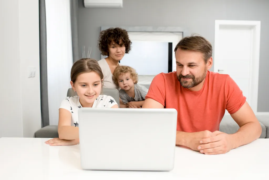 Man, woman, and two small children looking at laptop