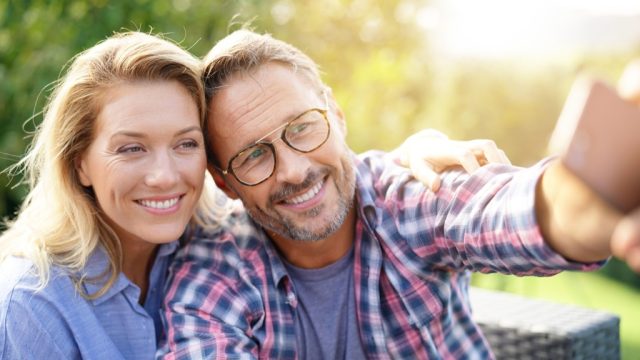 Portrait of cheerful mature couple taking selfie picture