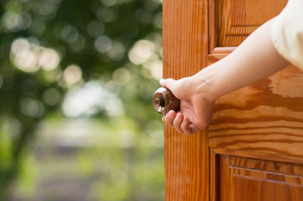 opening door with hand on doorknob