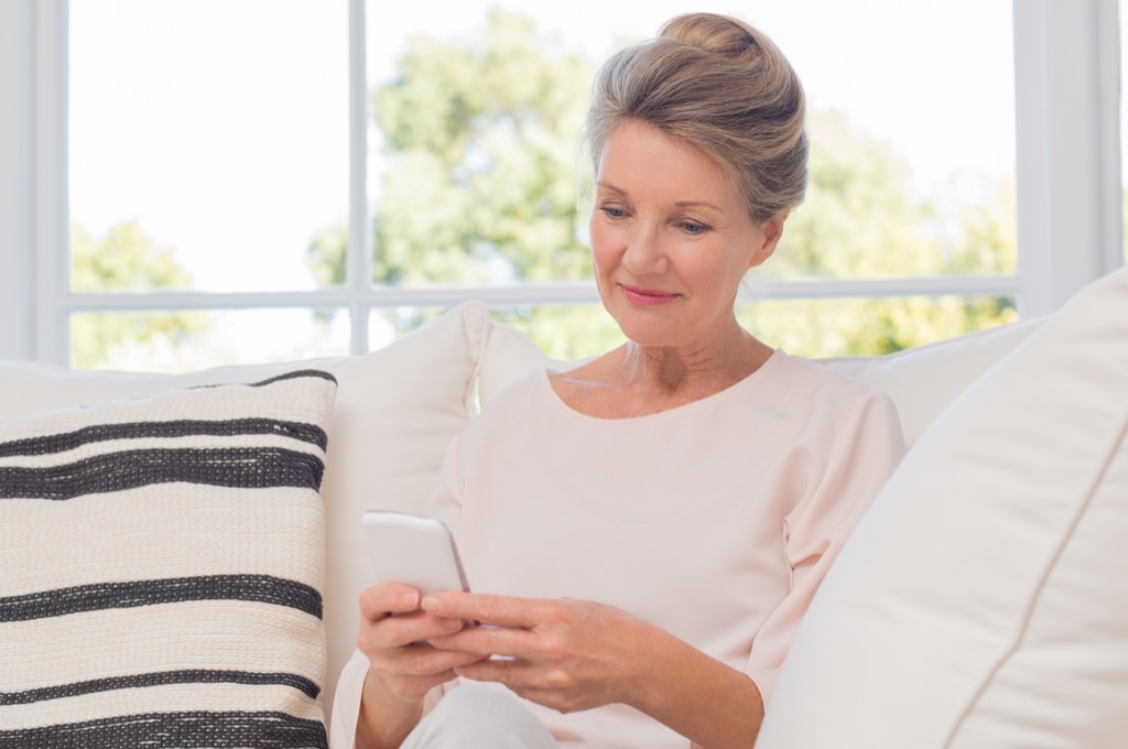 Older woman on smartphone things grandparents should never do