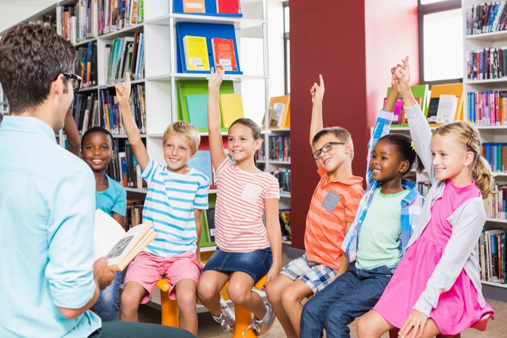 kids raising their hands to answer riddle