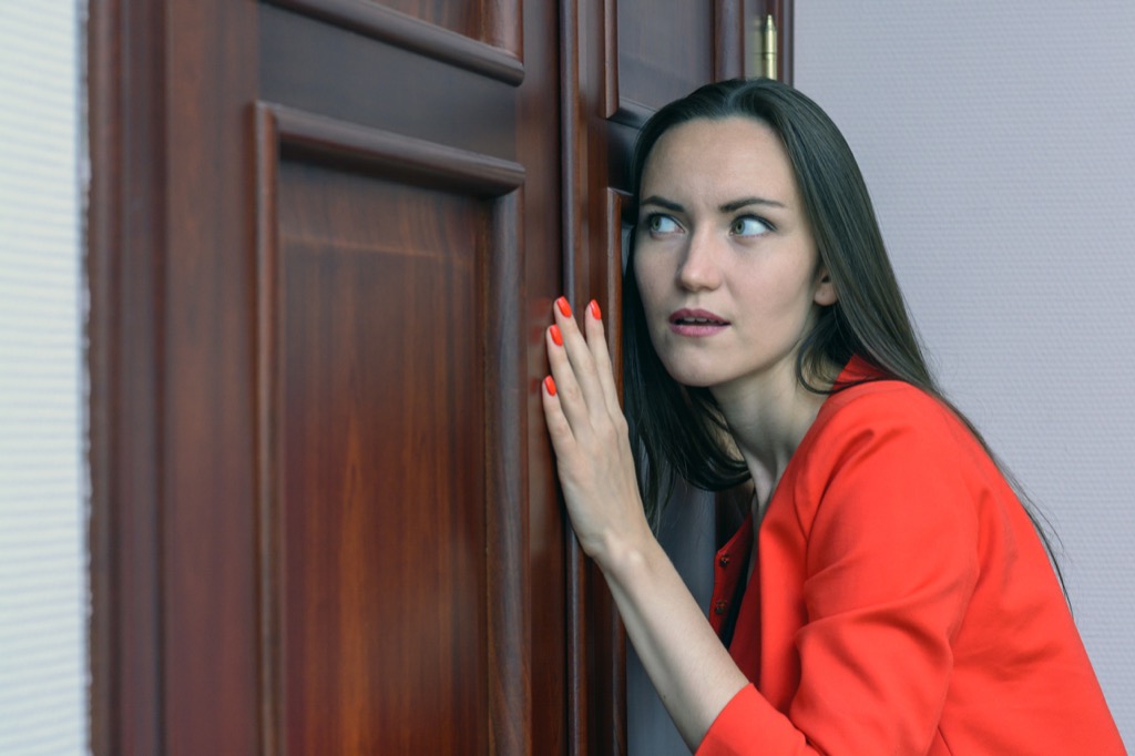 Woman eavesdropping at closed door