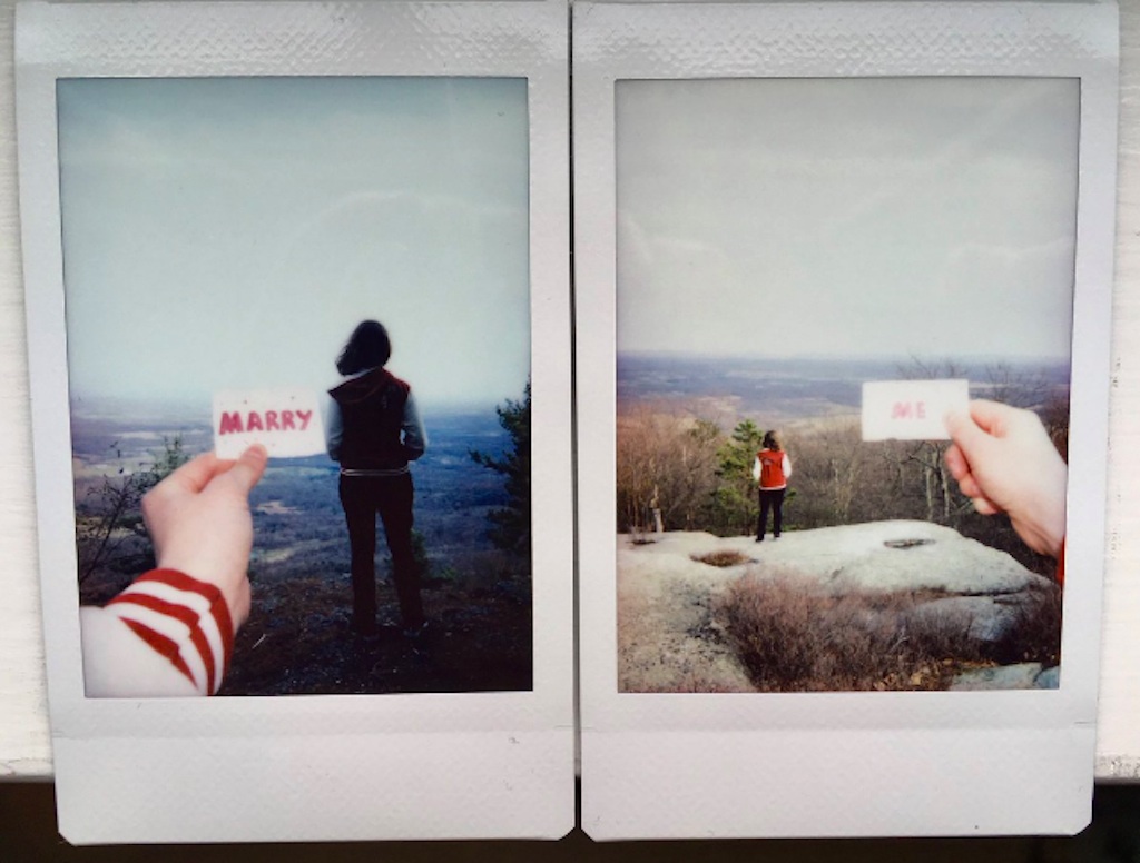 Meg proposes to Lyd on top of a mountain using Instant photos.